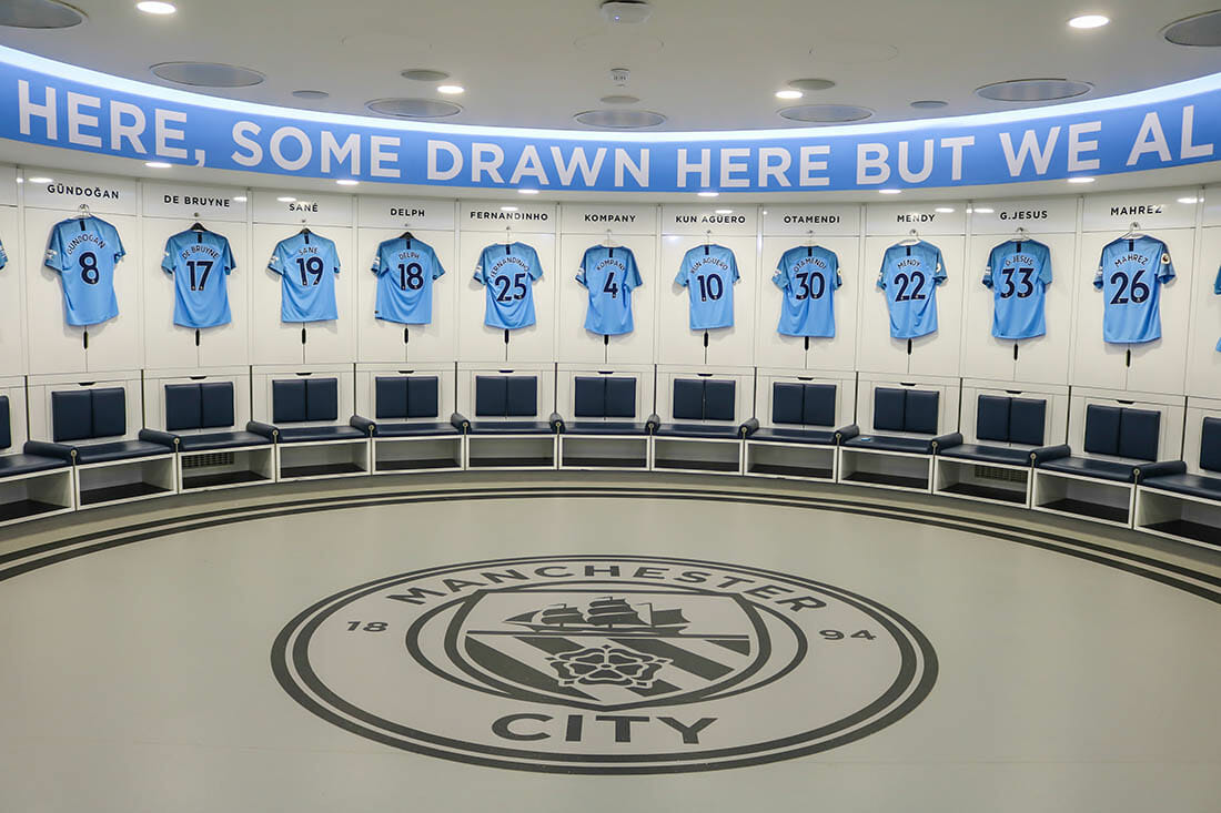 MANCHESTER - ENGLAND, MAY 16, 2019: Player's jerseys hung in front of lockers in the changing room at Etihad Stadium; the home ground of Manchester City Football Club.