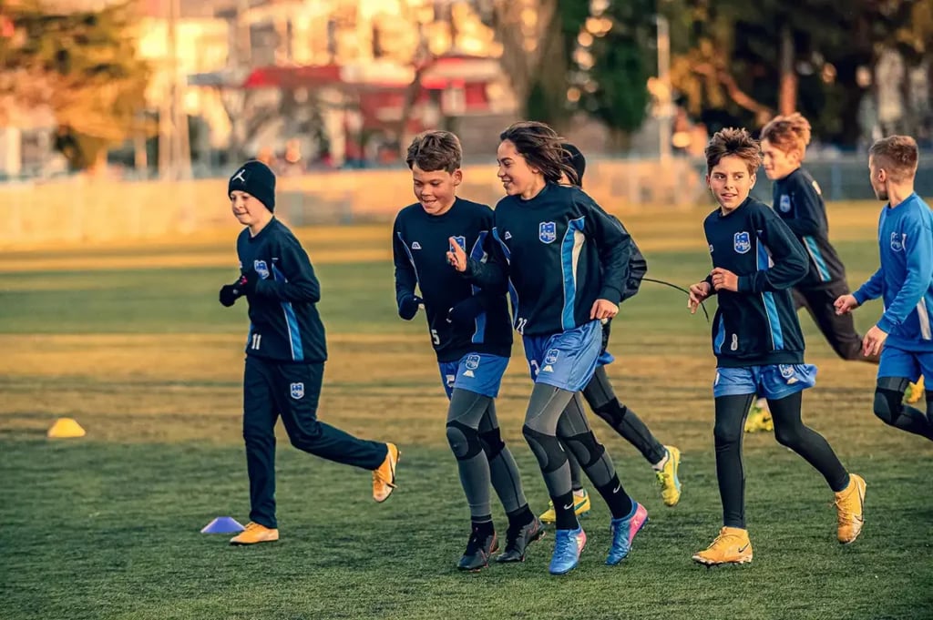 a group of youth boy footballers training on a field