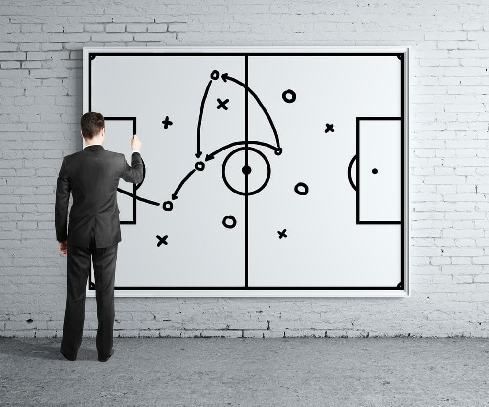 businessman drawing tactic scheme on board