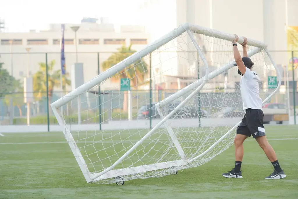 Soccer coach constructing a portable football goal