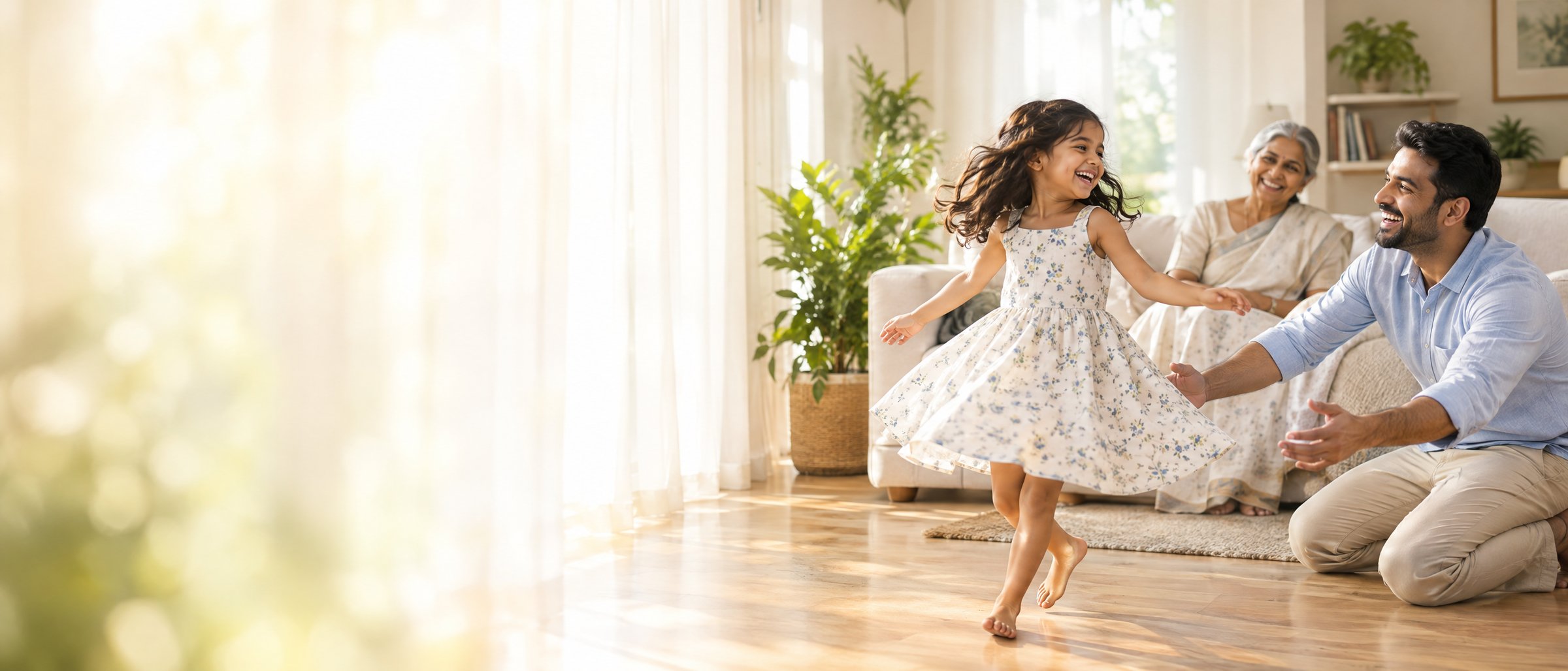 A little girl twirls barefoot across a sunlit living room as her father and grandmother laugh with her