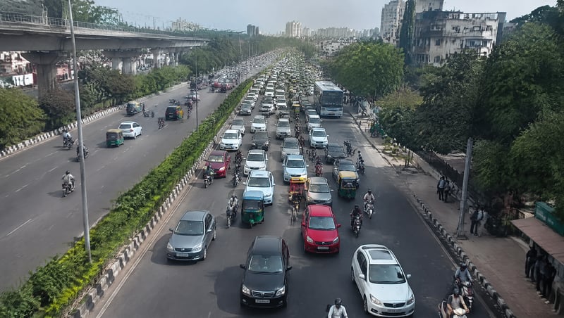 Aerial view of a busy Indian city road with many cars in traffic