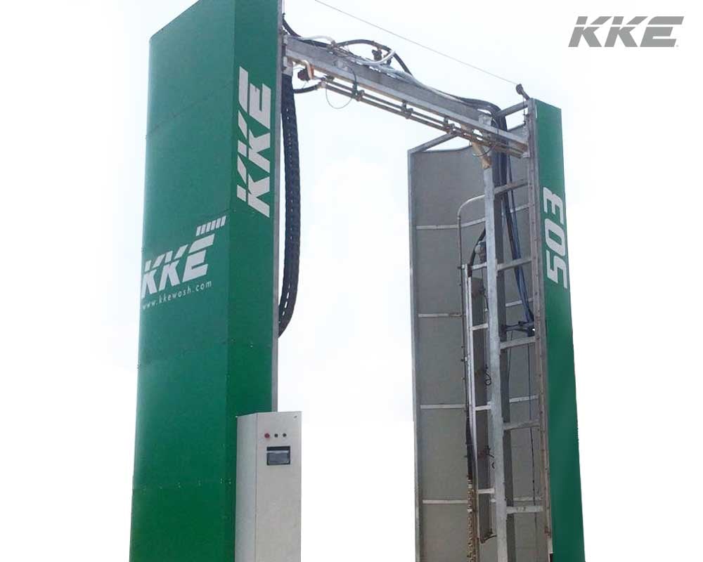 A KKE 503 touchless truck wash standing in the open: a green portal with the KKE mark down one column and 503 down the other, a stainless nozzle beam spanning the top and a vertical nozzle bar down the inside of the far leg