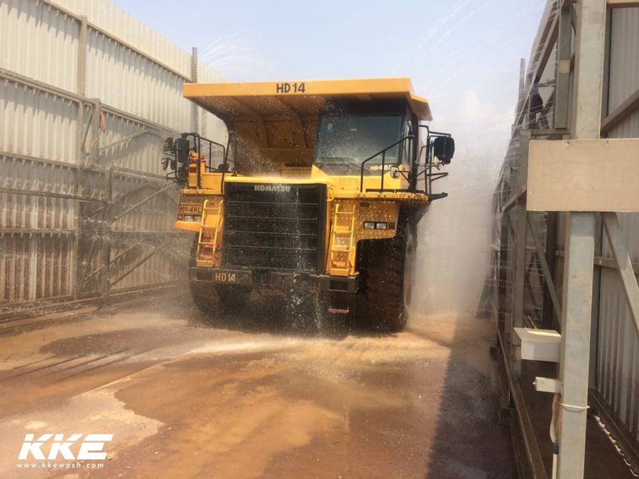 A mining haul truck being washed at a KKE installation, water running off the body and tyres