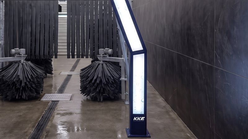 The brush stations of a KKE Z10 drive-through fleet car wash: blue vertical wrap brushes with a red rotating brush behind them
