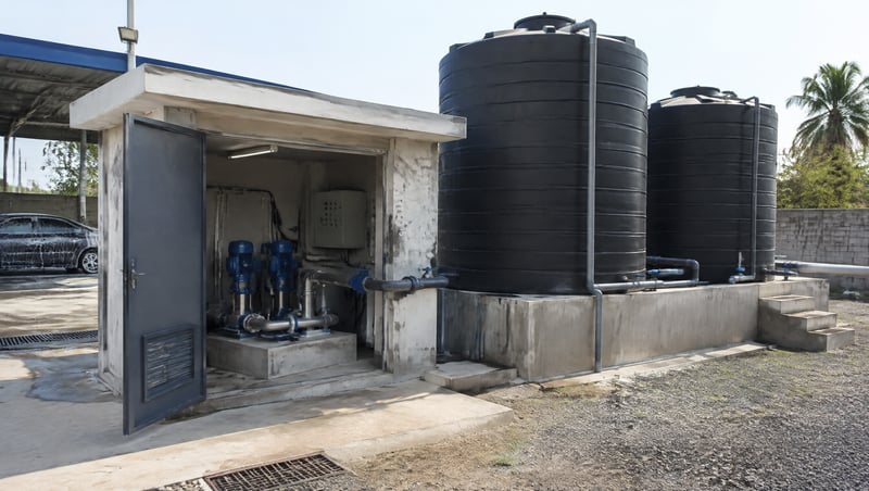 A groundwater pump house and water storage tanks at a car wash site