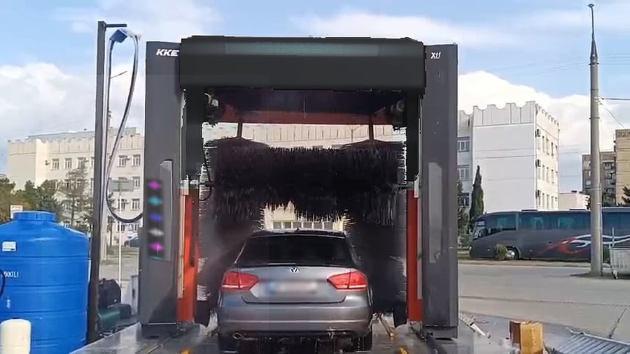 A clean saloon standing between the columns of a red KKE X1.1 at the end of its wash