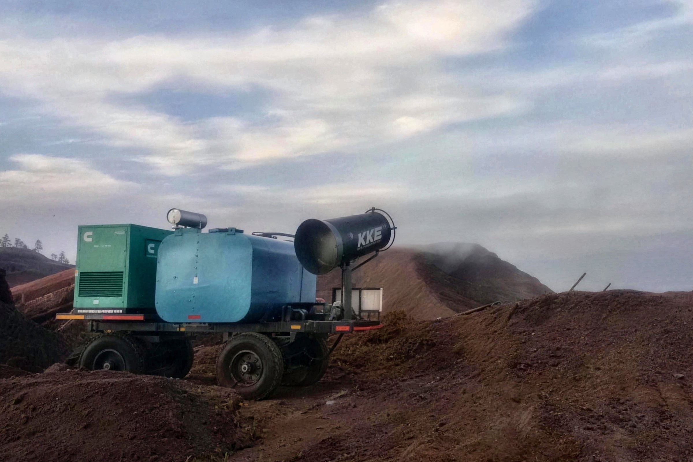 KKE MistBeam fog cannon on a four-wheel towable trolley with an onboard water tank and a diesel generator, parked on an overburden bench