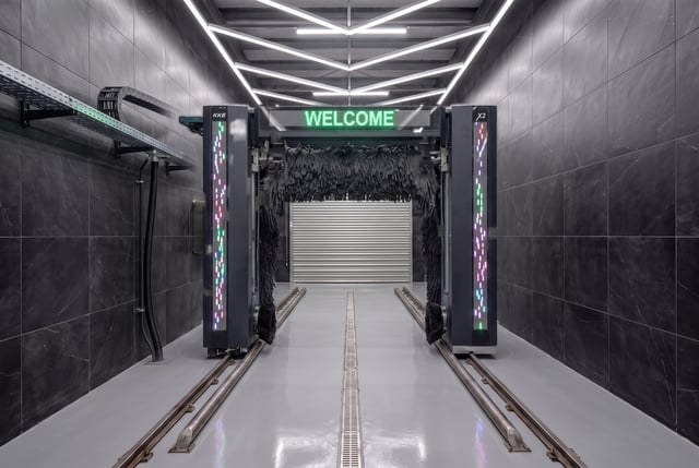 The lit entrance of an automatic car wash bay