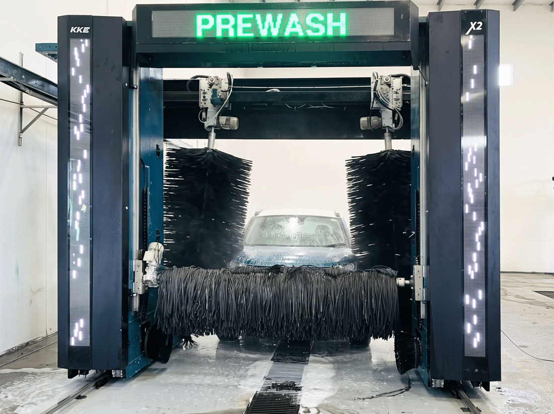 Vehicle in a commercial automatic wash bay with floor drainage channel