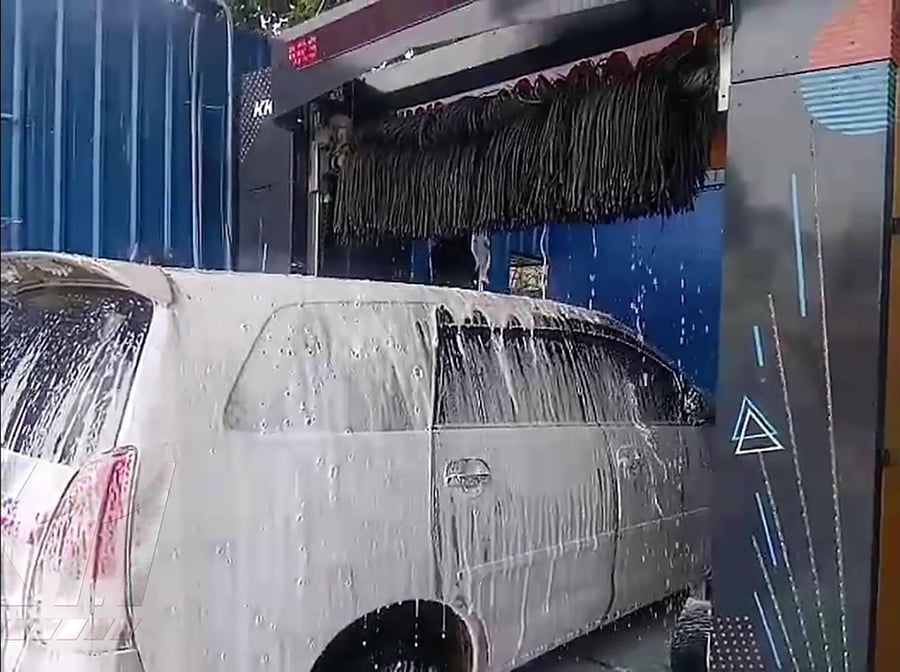 Foam sheeting down the flank of a silver MPV inside a KKE X1.1 bay