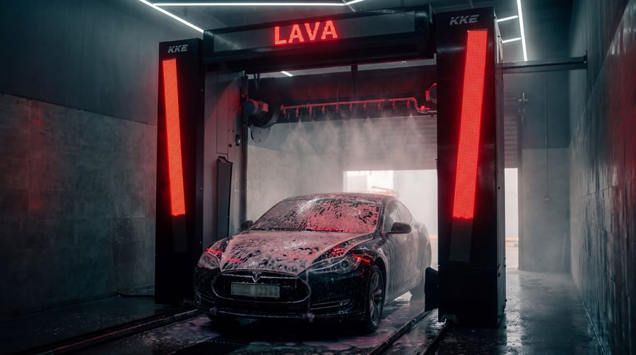 A car under a KKE Wave being covered in foam, the display reading LAVA in red