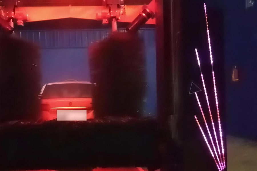 Two vertical brushes of a KKE X1.1 silhouetted against the red glow of the beam at night