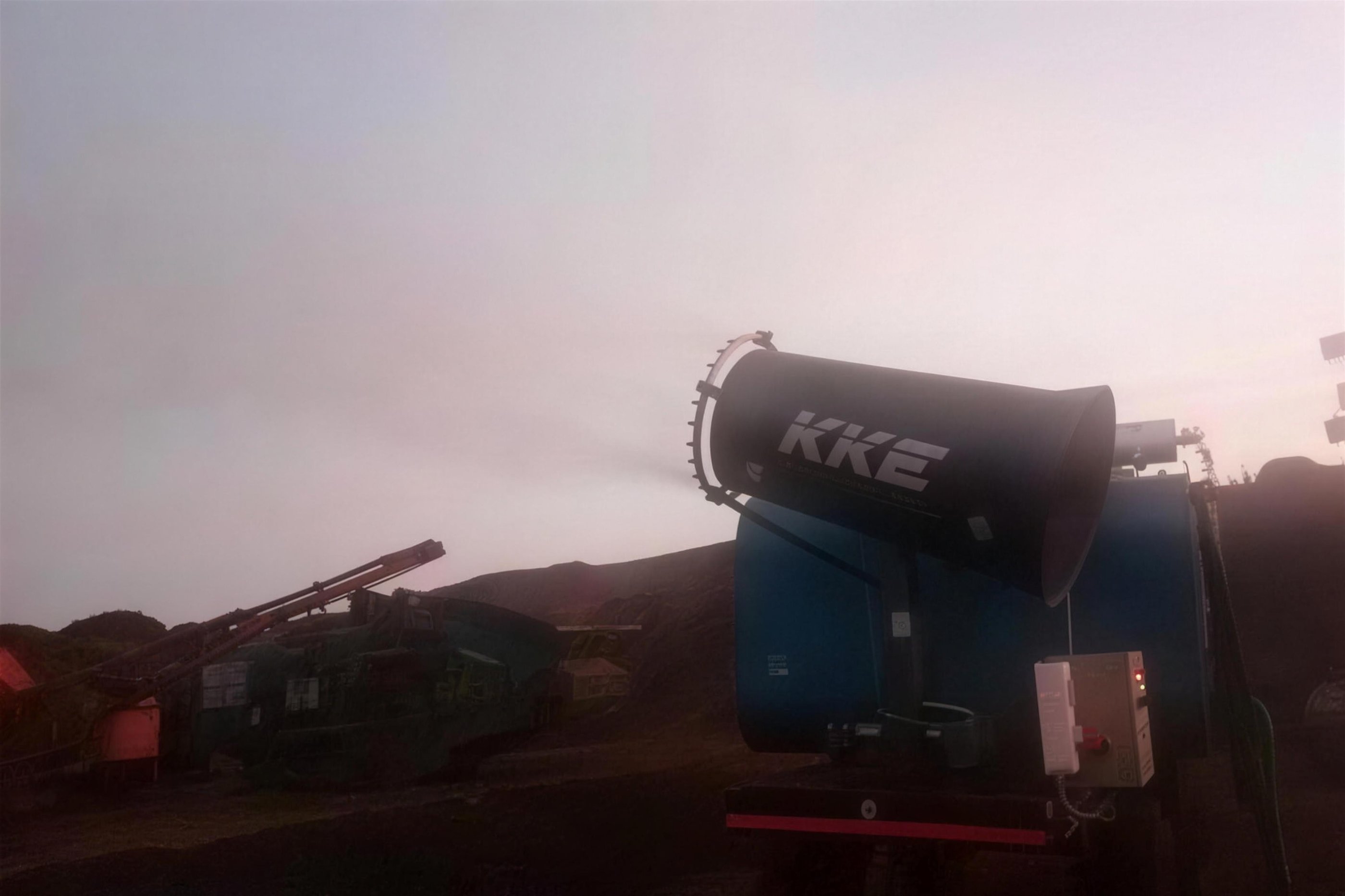 KKE MistBeam fog cannon throwing atomised mist across an opencast mining bench at dusk