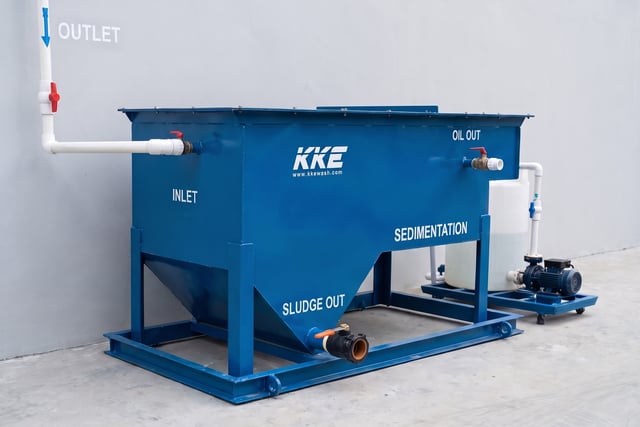 KKE W100 oil–sludge separator — blue sedimentation tank with inlet, oil-out and sludge-out connections, transfer pump alongside