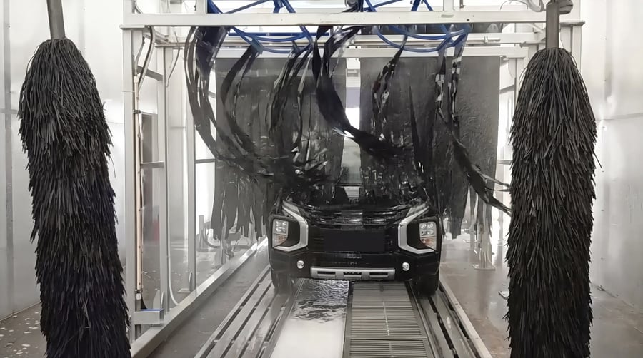 Inside a KKE Gamma conveyor tunnel: mitter curtain and both wrap brushes working