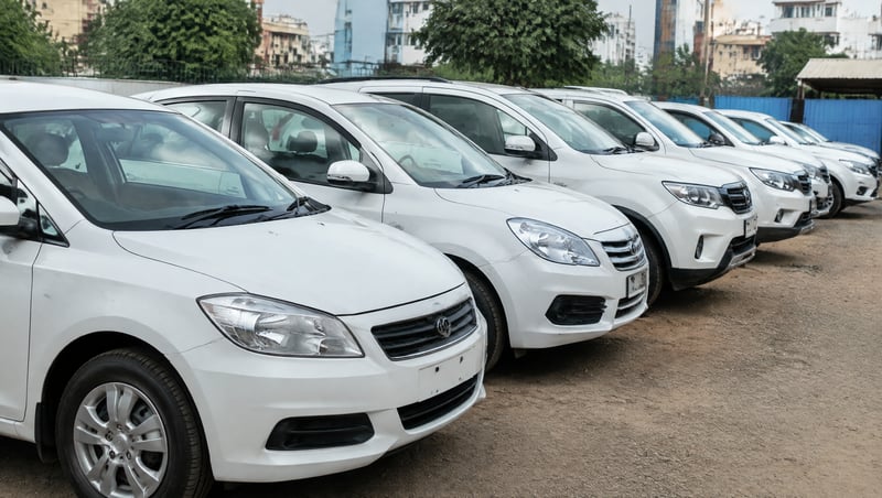 A row of parked cars at a used car lot in an Indian city
