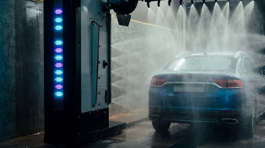 A car inside the bay seen past a gantry column carrying a strip of violet LEDs