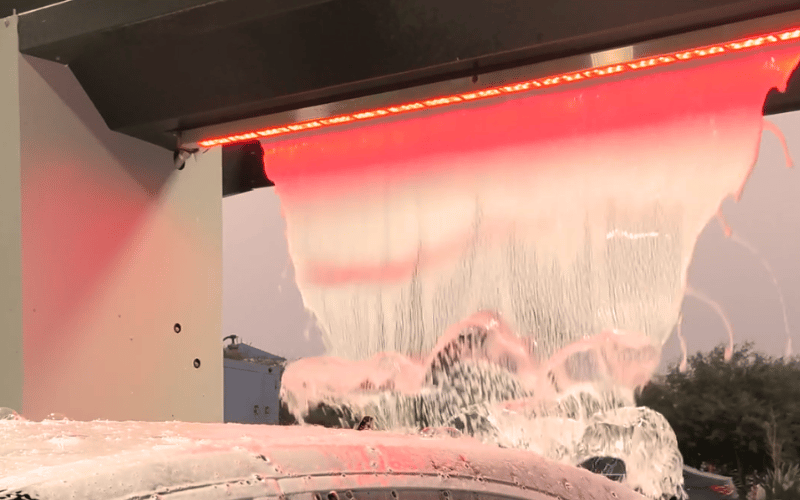 Vehicle covered in lava foam inside a KKE ArrowClean wash bay