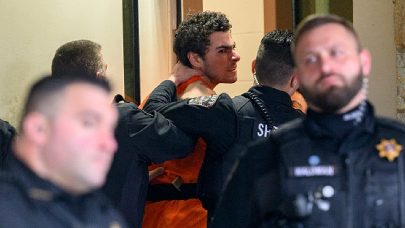 Graduado enfrenta a los medios durante la audiencia de extradición por los impactantes cargos de asesinato del CEO.