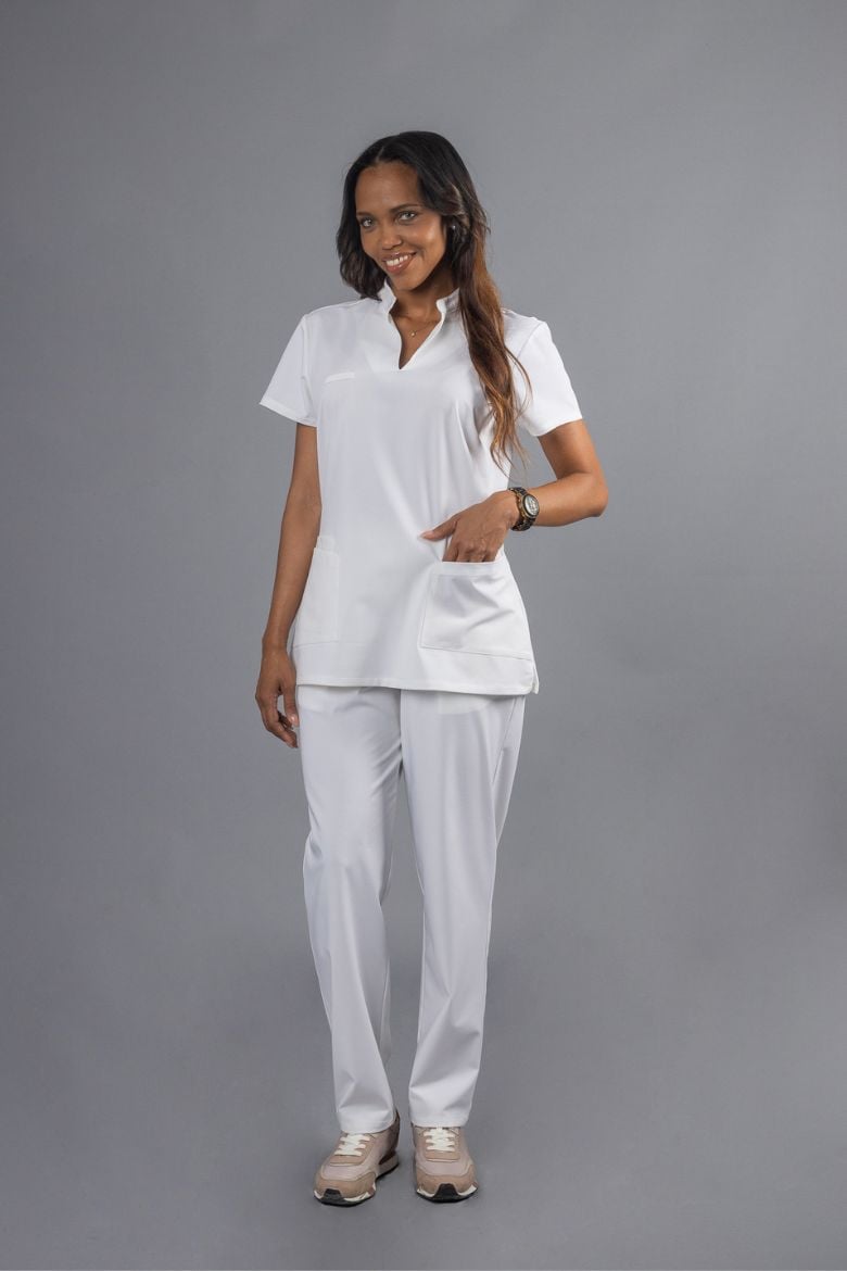 Health professional wearing a Women's White Tunic and white trousers, designed to be used as a professional uniform.
