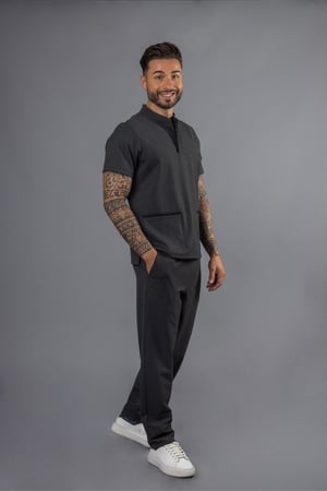 Homem vestido com um uniforme profissional de cor cinza para ser usada como vestuário para a área da saúde fabricado pela Unifardas