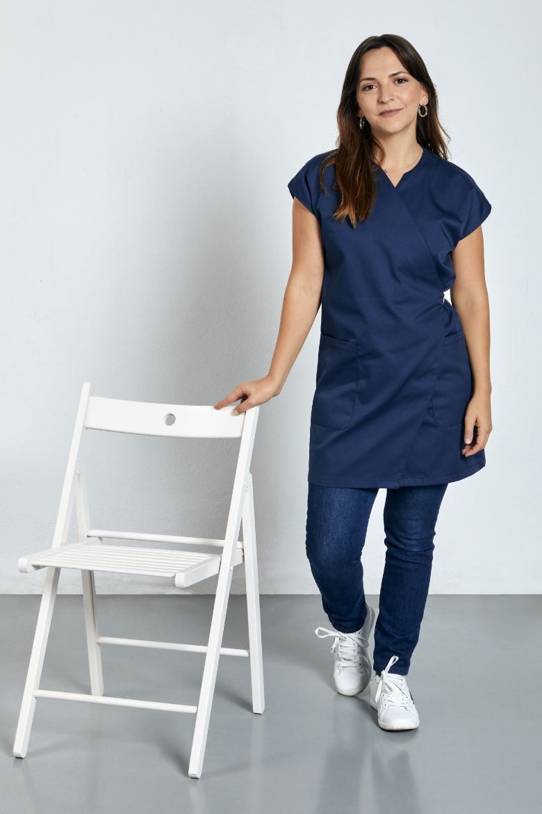 Senhora vestida com uma bata de trespasse azul marinha para ser usada como Uniforme Profissional fabricado pela unifardas