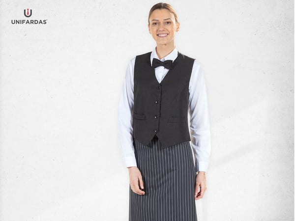 A hotel and restaurant worker wearing one of the customized vests for companies manufactured by Unifardas