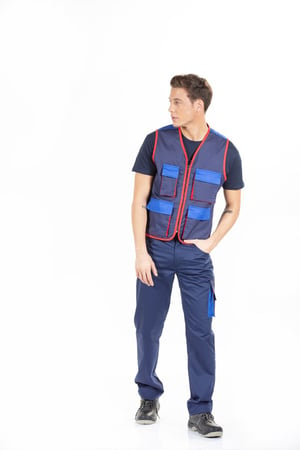 Trabalhador vestido com um colete de homem azul marinho e com contrastes vermelho e calças multibolsos para ser usado como uniforme de trabalho