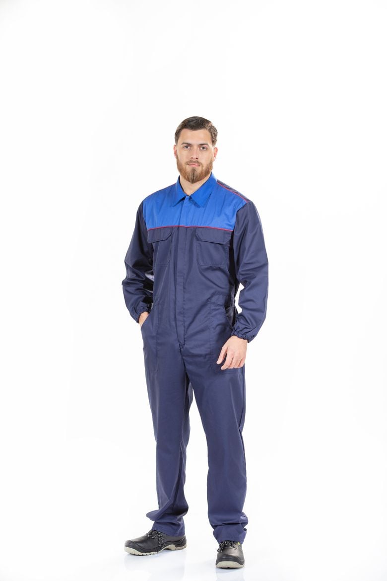 Trabalhador da Indústria vestido com um fato macaco masculino de cor azul com contrastes m vermelho fabricado pela Unifardas