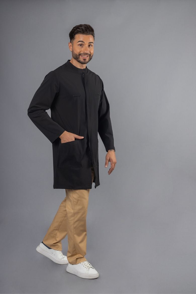 Homem vestido com Bata Preta de Trabalho e calças beges, para ser usada como Farda de Trabalho para a área da saúde e bem-estar
