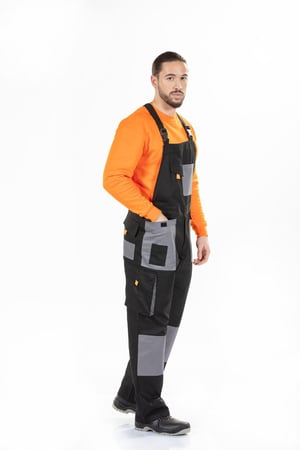 A worker dressed in a man's overalls to be worn as a work uniform manufactured by Unifardas