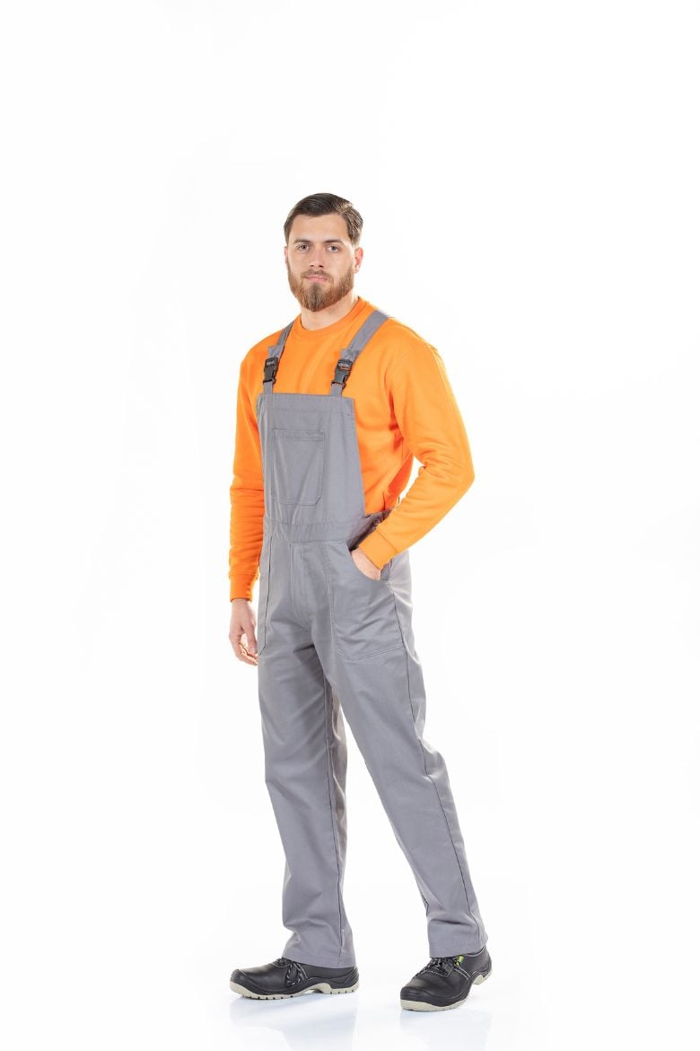 Trabalhador vestido com uma jardineira de trabalho com bolso no peito fabricada pela Unifardas