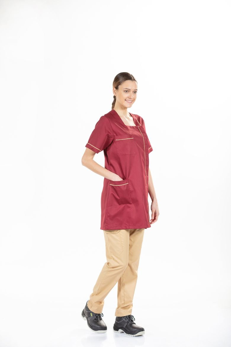 Senhora vestida com uma bata de trabalho de manga curta de cor vermelha para ser usada como farda de trabalho fabricada pela Unifardas