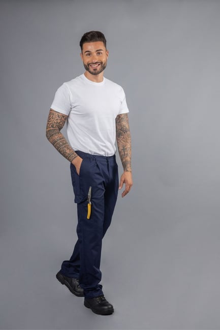 Trabalhadora da área da saúde vestida com uma túnica azul com contrastes a branco e uma calça azul com contraste branco para ser usada como farda profissional para a área da saúde