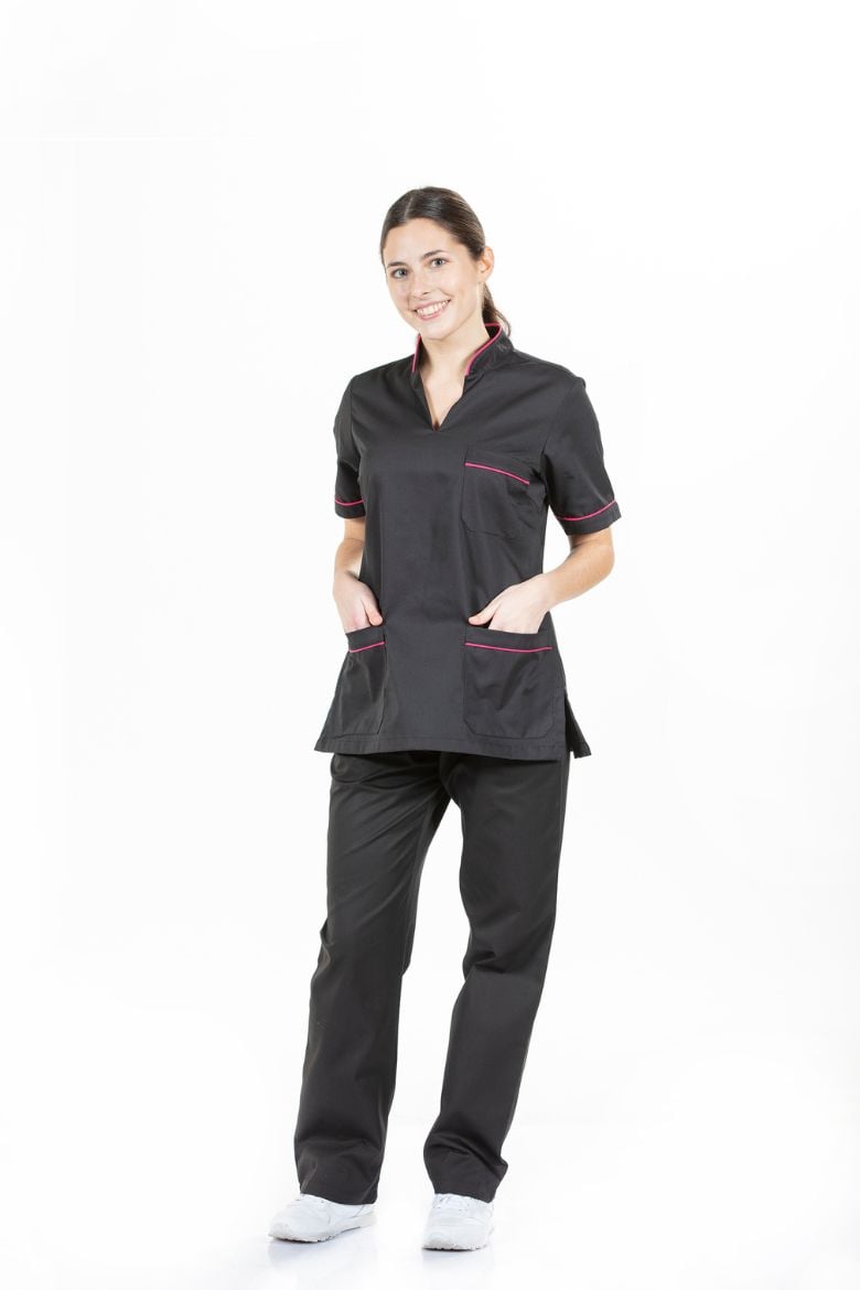 Senhora vestida com umas calças pretas e uma túnica para farda de trabalho em preto com um contraste em rosa fabricado pela Unifardas