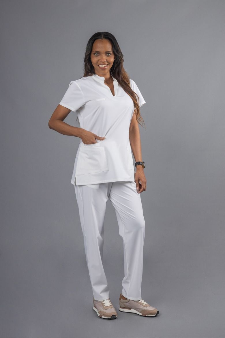 Senhora vestida com uma calça branca de trabalho e uma túnica branca com gola chinesa fabricada pela Unifardas para serem usadas como Roupa de Trabalho