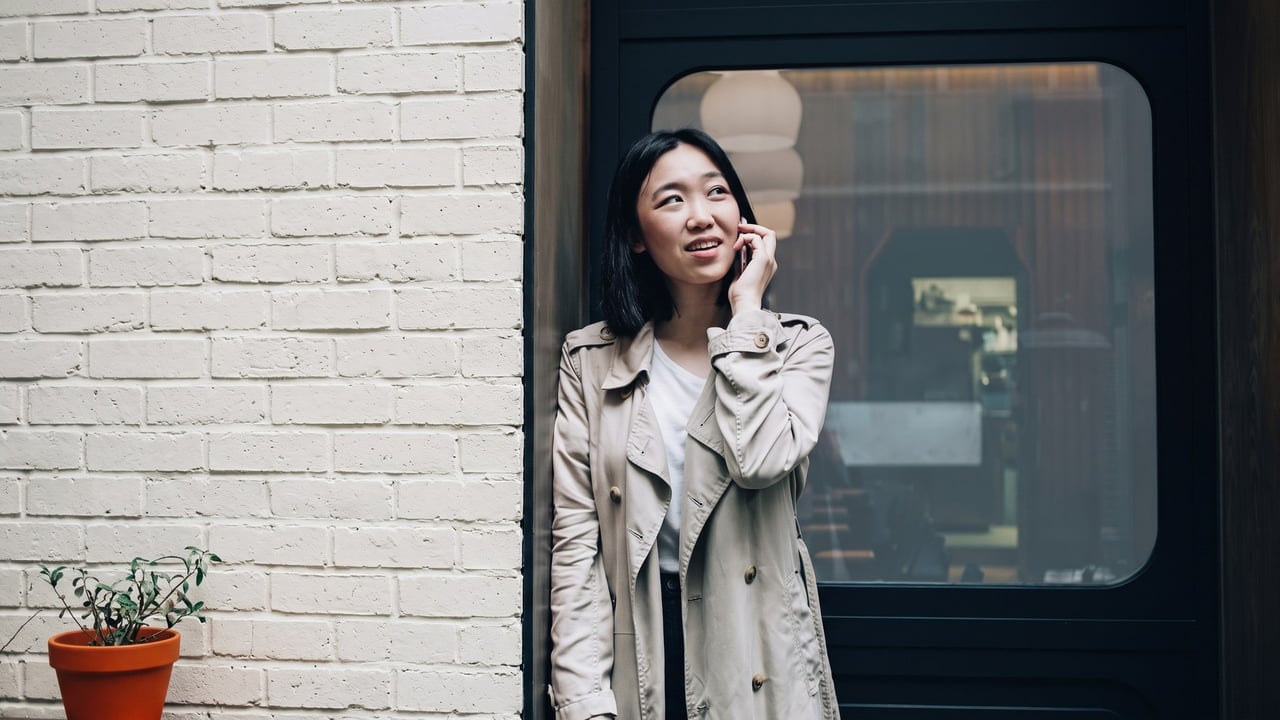 Woman on the phone outside a locked front door
