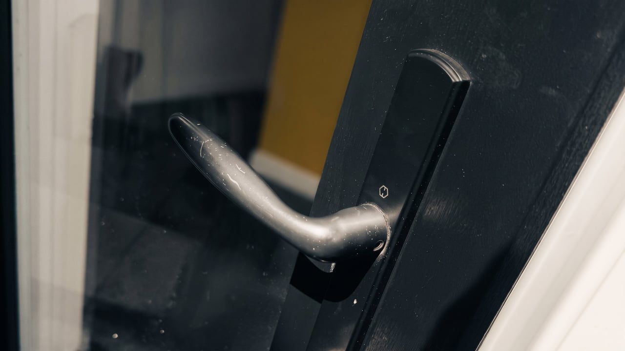 Damaged lever handle on a glass entry door after a break-in