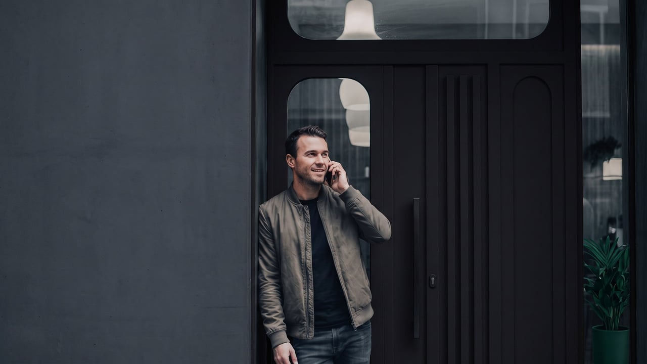 Man on the phone outside his locked front door