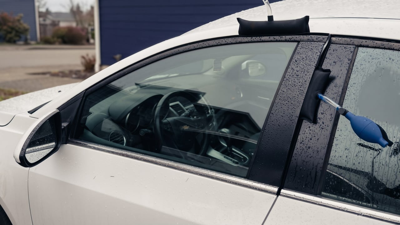 Locksmith opening a locked car door with an air wedge