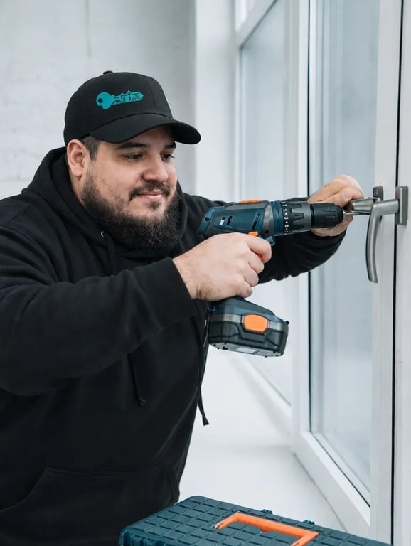 Locksmith fitting a window handle with a cordless drill