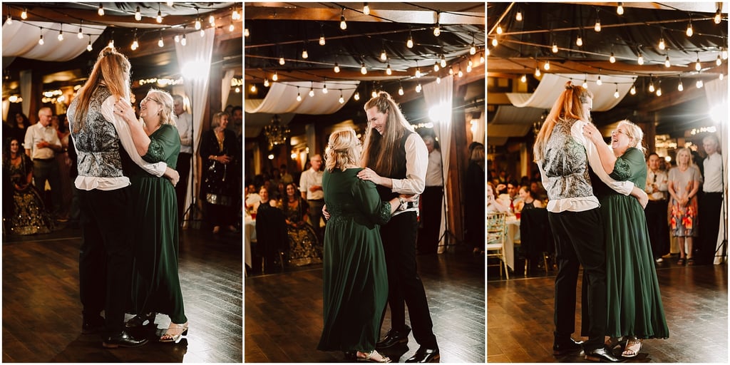 Couple dances closely under hanging bulbs as guests watch; woman in green dress and man in patterned vest share a moment at a reception.