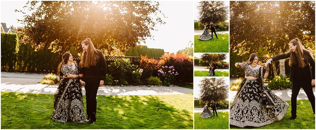 Couple dancing in a sunlit garden; woman in an ornate black and gold lehenga and man in a black suit smile at each other as they hold hands.