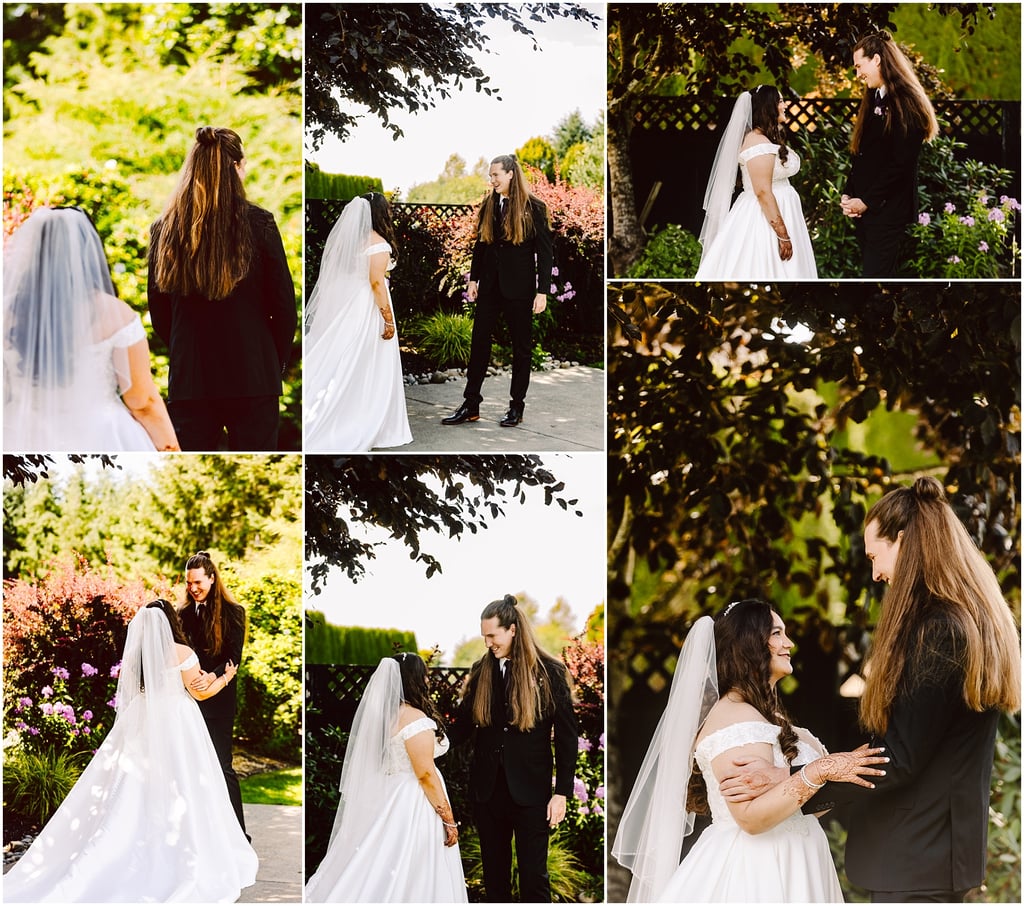 Bride in a white wedding gown with veil stands with a groom in a black suit in a sunlit garden.