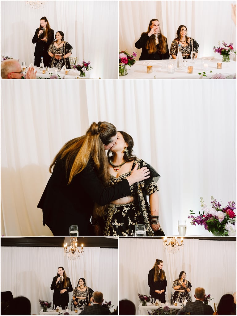 Man with microphone speaking at a decorated wedding table while a woman in a jeweled black outfit smiles beside him.