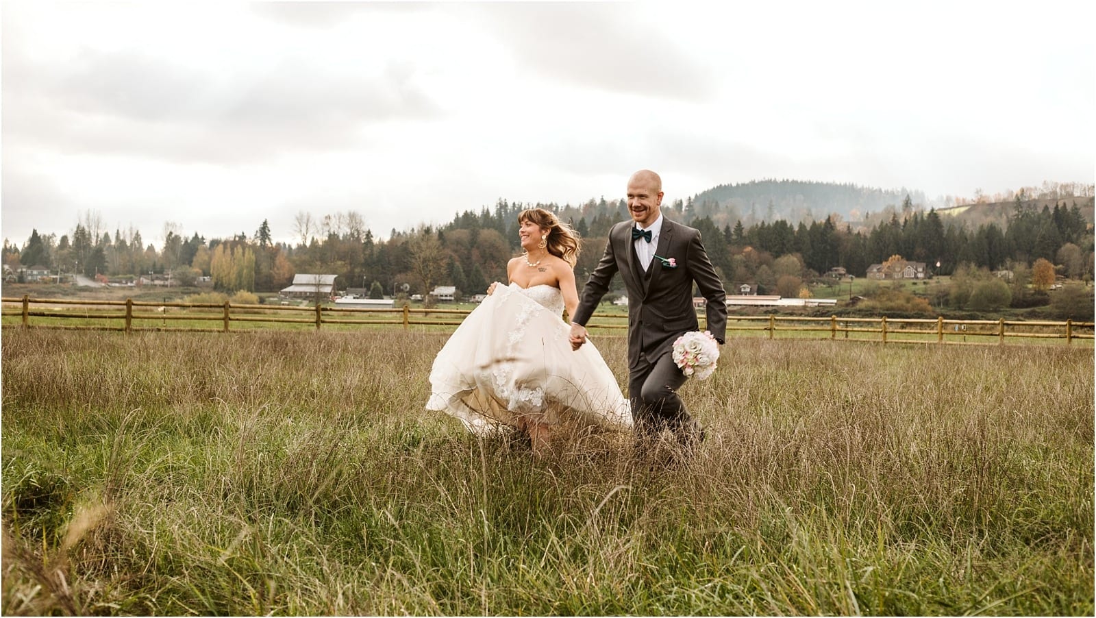 Premier Snohomish & Seattle Wedding Photographer | GSquared Weddings Photography A bride and groom smile and run through a grassy field during their Snohomish wedding, with trees and houses in the background under a cloudy sky. The groom holds a bouquet while the bride lifts her dress slightly as they move. 47.9129° N, 122.0982° W | Serving Snohomish, Seattle , Orlando & Beyond