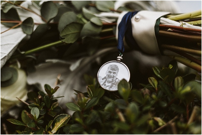 Premier Snohomish & Seattle Wedding Photographer | GSquared Weddings Photography A close-up of a bouquet of flowers at a Snohomish wedding, with a round photo pendant attached, showing a smiling man in black and white, nestled among green leaves and stems. 47.9129° N, 122.0982° W | Serving Snohomish, Seattle , Orlando & Beyond