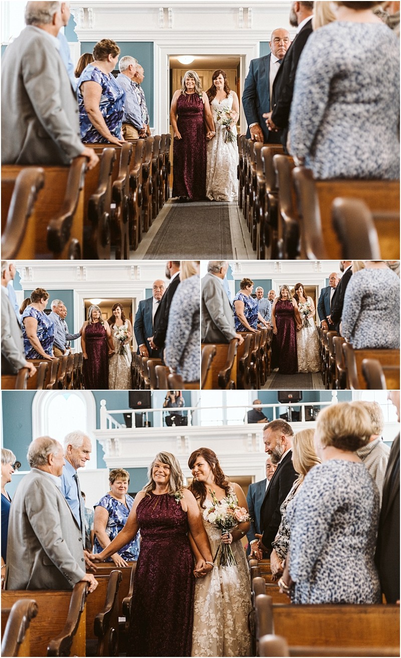 Premier Snohomish & Seattle Wedding Photographer | GSquared Weddings Photography A bride in a white dress walks down a church aisle, arm-in-arm with a woman in a purple gown, smiling at guests during this elegant Snohomish Seattle wedding ceremony surrounded by stunning architecture and joyful onlookers. 47.9129° N, 122.0982° W | Serving Snohomish, Seattle , Orlando & Beyond