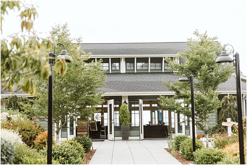 Premier Snohomish & Seattle Wedding Photographer | GSquared Weddings Photography A path lined with black lamp posts and trees leads to a modern building with large windows and a covered porch—an ideal Snohomish Seattle wedding or engagement venue, surrounded by green shrubs and colorful flowers. 47.9129° N, 122.0982° W | Serving Snohomish, Seattle , Orlando & Beyond